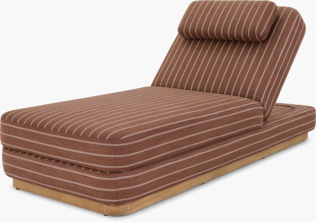 Brown chaise lounge with white pinstripes, featuring a cushioned seat, backrest, and headrest. The base is made of light wood, and the overall design is modern and minimalist.